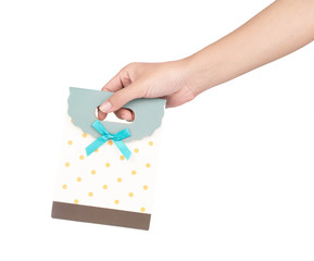 Sticker - hand holding gift craft paper bag with green bows, ribbon isolated on white background