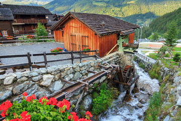 Wall Mural - Traditional ancient sawmill with water wheel and river in the picturesque village of Grimentz, Switzerland, in summer
