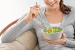 © Pixel-Shot - Young woman eating fresh salad at home. Healthy food concept
