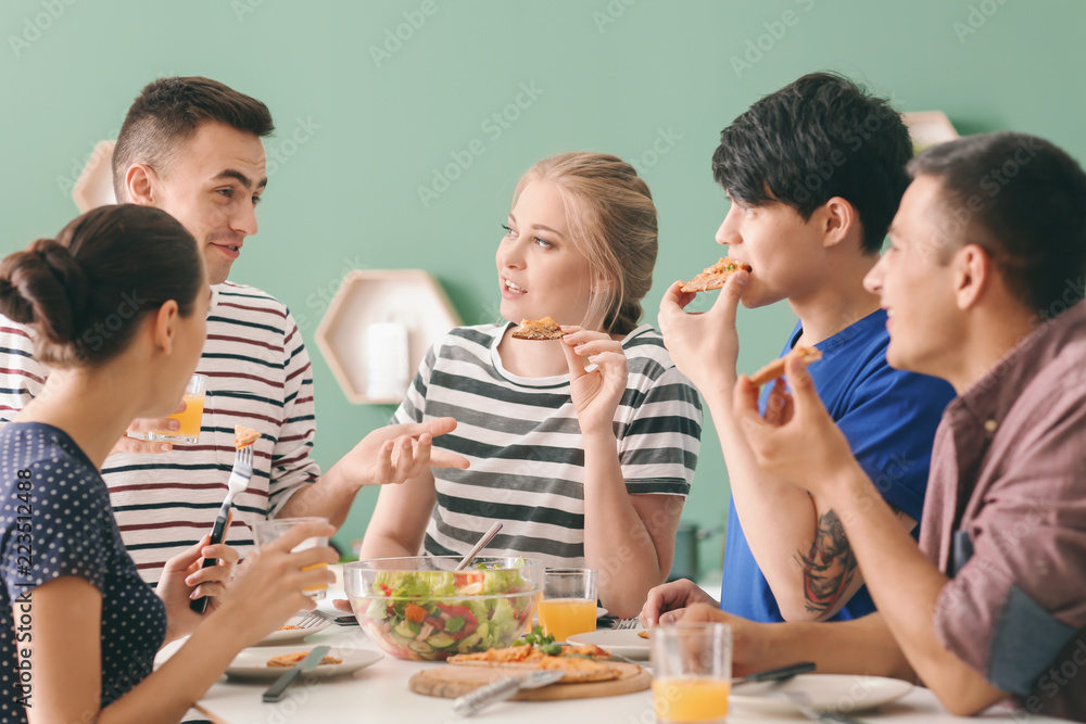 Friends eating at table in kitchen
