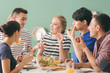 © Pixel-Shot - Friends eating at table in kitchen