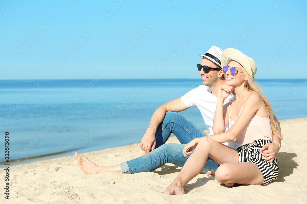 Happy young couple near sea on summer day