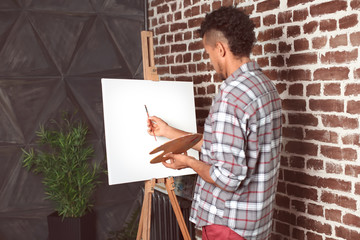 Wall Mural - Young African-American artist painting picture in workshop