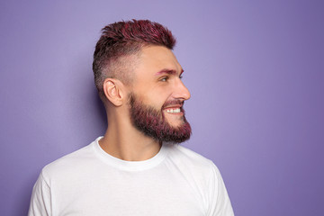 Poster - Portrait of handsome man with dyed hair and beard on color background