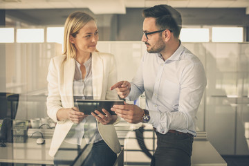 Wall Mural -  Business woman showing something to her colleague on digital tablet.