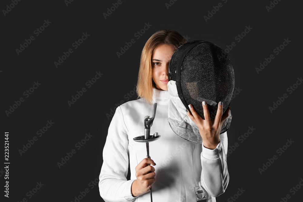 Young female fencer on dark background