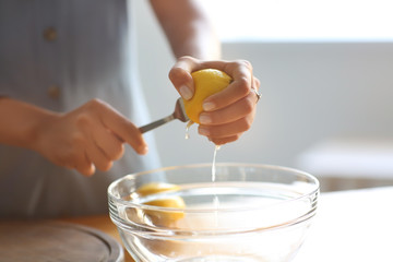 Young woman preparing fresh lemonade at home