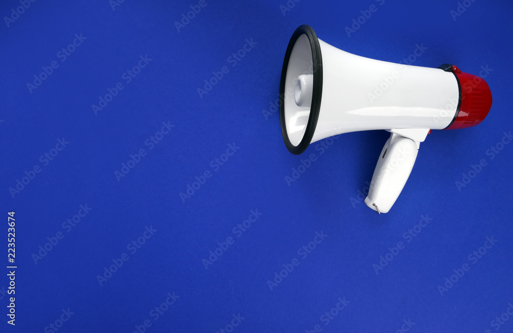 Megaphone on color background