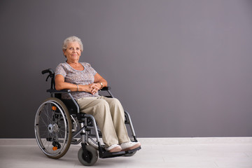 Poster - Senior woman in wheelchair near grey wall