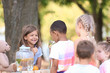 © Pixel-Shot - Adorable children waiting in queue for natural lemonade near stand in park