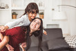 Mother and daughter doing piggyback in funny gesture emotion at home. Young sister playing with girl in good relationship lifestyles relaxation. Happy family and home sweet home theme concept
