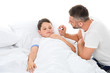 © LIGHTFIELD STUDIOS - father measuring body temperature to sick son, isolated on white