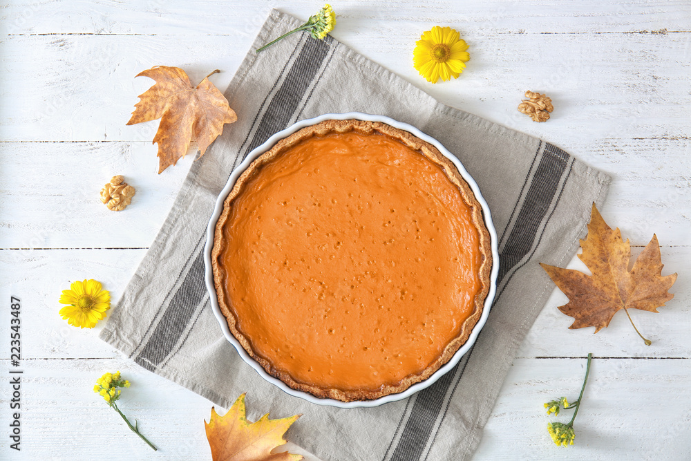 Baking dish with tasty pumpkin pie on white wooden table, top view