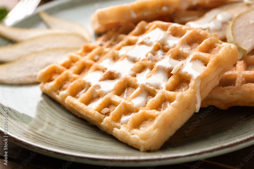 Delicious waffles with sauce on plate, closeup