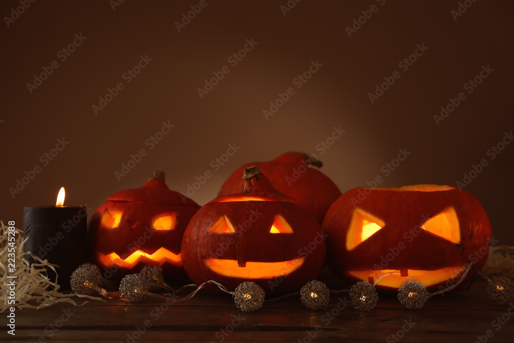 Halloween pumpkins with garland on wooden table