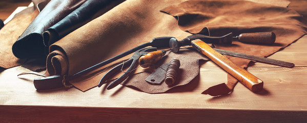 shoemaker's work desk. tools and leather at cobbler workplace. set of leather craft tools on wooden 