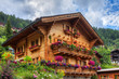 Beautiful traditional wooden house in the alpine village Grimentz, Switzerland, in the canton Valais, municipality Anniviers, with geranium flowers on the balconies
