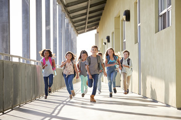 Wall Mural - Group of elementary school kids running in a school corridor