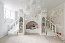 Interior Of A Spacious Children's Room. Decorative Castle With Bed Inside, Game Slide And Stairs