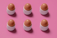 High Angle View Of Brown Eggs In Bowls Arranged On Pink Background