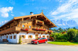 © pkazmierczak - Traditional wooden alpine house decorated with flowers in Going am Wilden Kaiser mountain village on sunny summer day, Tyrol, Austria