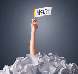 Wall Mural - Female hand emerging from crumpled paper pile holding a white flag with help written on it