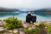 Couple Admiring The View At Lake Louise On A Foggy Day