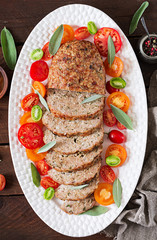 Wall Mural - Tasty homemade ground  baked turkey meatloaf in white plate on wooden table. Food american meat loaf. Top view. Flat lay