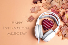 International Music Day Background With White Headphones, Red Knitted Heart And  Autumn Maple Leaves.