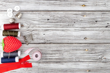 Concept of sewing and tailoring. Tools on wooden background