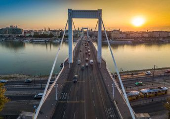 Wall Mural - Budapest, Hungary - Beautiful Elisabeth Bridge (Erzsebet hid) at sunrise with golden and blue sky, traditional yellow tram and heavy morning traffic