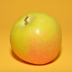 Ripe Apple with red side isolated on yellow background