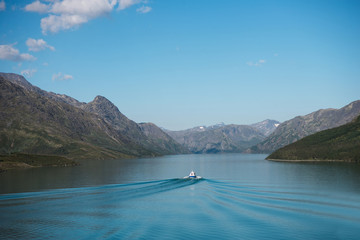 Sticker - boat floating on calm blue water of Gjende lake, Besseggen ridge, Jotunheimen National Park, Norway