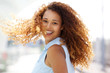 © mimagephotos - happy young woman with curtly hair turning around