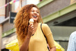 © mimagephotos - happy young woman laughing with ice cream in the city