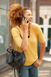 © mimagephotos - attractive young woman walking and talking on mobile phone in the city