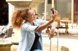 © mimagephotos - happy young woman taking selfie outside in the city