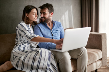 Wall Mural - couple with laptop spending time together at home.