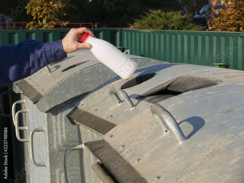 Fotografie, Obraz Man throws a plastic bottle into a garbage can