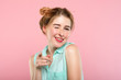 © golubovy - emotion and facial expression. flirty coquettish woman pleased with herself smiling and winking at viewer. young beautiful girl portrait on pink background.