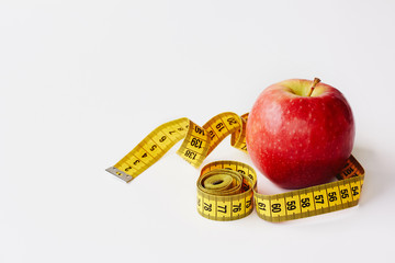 Measure tape and fresh fruit apple on white background. Loss weight, slim body, healthy diet concept