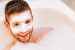 © anastas_ - Young man with a facial mask lies in a foam in the bathroom.Concept spa for men.