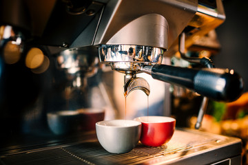 Wall Mural - Close up details of brewing machinery pouring and preparing espresso in two cups. Cafe shop details