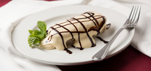 Wall Mural - Tiramisu with chocolate drizzle and mint garnish plated with fork