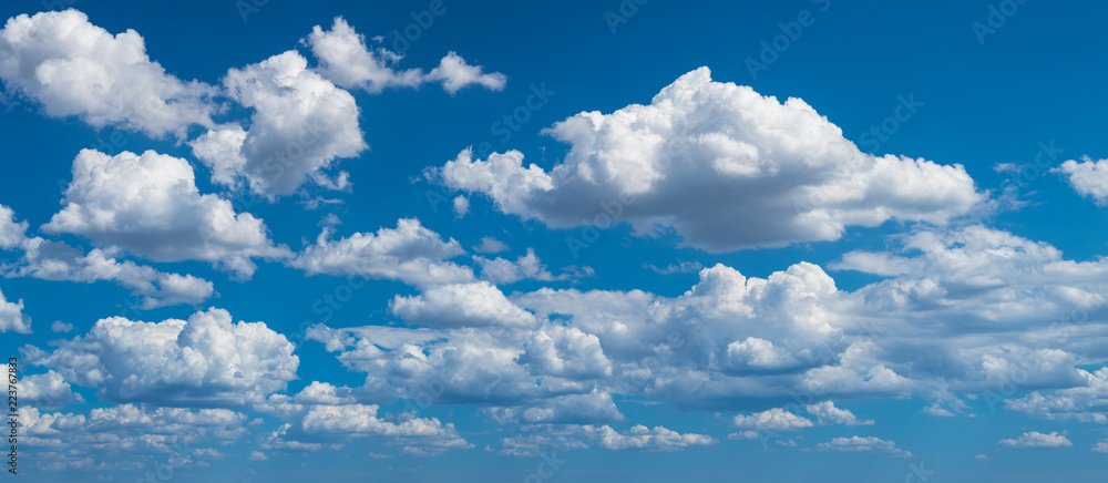 Romantic panoramic cloudscape with azure blue heaven. Idyllic sunlit panorama with flowing white fluffy clouds. Beautiful clear sky in background. Sunny summer day. Idea of climate, weather, ecology. - obrazy, fototapety, plakaty 
