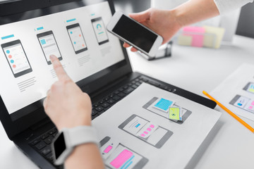 app design, technology and business concept - web designers or developers with laptop computer and s