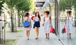 © Syda Productions - sale, consumerism and people concept - happy young women with shopping bags and drinks walking along city street