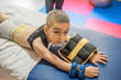 © Ivan - little boy lying on stomach during physiotherapy and look at camera