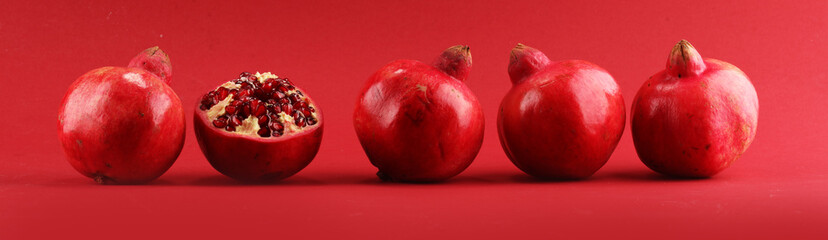 Wall Mural - Ripe Pomegranates. sliced and whole pomegranate on a table.