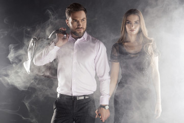 Wall Mural - Young handsome man and beautiful woman with smoke around. Jorney or adventure concept